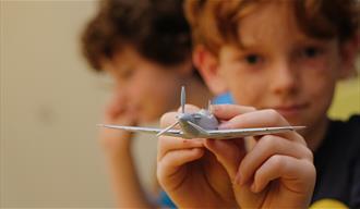 Boy at The D-Day Story showing off an Airfix model of an aeroplane - credit Matt Scott-Joynt