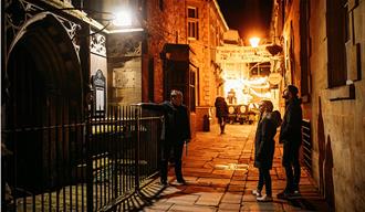 A tour guide pointing out a church to two participants
