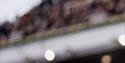Cheltenham Festival men's style - male race goer dressed in suit in the grandstand
