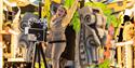 An enthusiastic female character standing next to an old film camera on a brightly-coloured Hollywood-themed carnival float at the Weston-super-Mare c