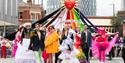 Group of people on Parade with the sign 'Queerly  Beloved'