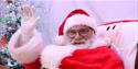 Santa is smiling and waving at the camera