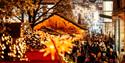 Bristol Christmas Markets 2022 Christmas lights and stalls with Cabot in background CREDIT James Bridle