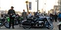 Man stands next to his chopper bike