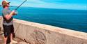 a man fishing off Babbacombe seafront