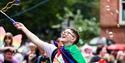 Person making bubbles with rainbow flag tied round them