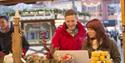 Couple browsing the festive gifts at one of Bournemouths Christmas market stalls