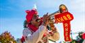 Man dressed in red and white playing a trumpet on a sunny day in Bournemouth