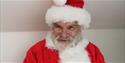 A close up image of Santa smiling.
