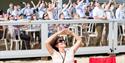 Woman shields her eyes from the sun while watching the air show above