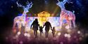 Family surrounded by illuminated Christmas decorations