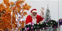Santa is waving at the camera from a winter wonderland