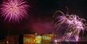 Castle in gold lighting with purple fireworks over