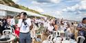 Photographer points his camera towards the skies with seated people in background
