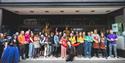 A large group of people stood in a shop front doorway