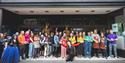 A large group of people stood in a shop front doorway