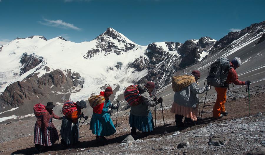 Women in traditional dress, climbing a mountain