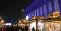 St George's Hall lit up with Christmas lights and wooden chalets decorated in Christmas lights