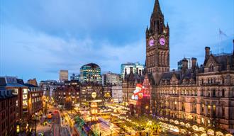 Manchester Christmas Market in Albert Square including the stalls and 'Zippy' the giant Father Christmas that sits on Manchester Town Hall