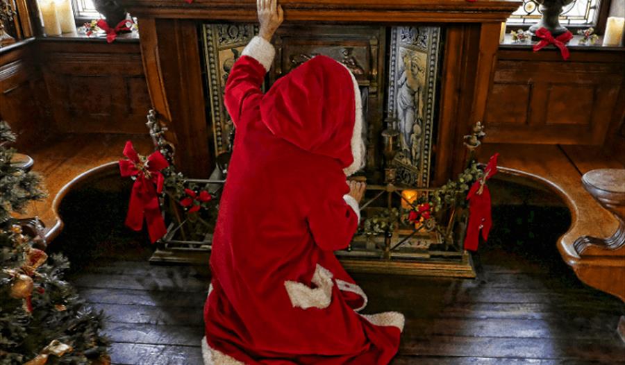 Father Christmas in front of the fireplace at Russell-Cotes