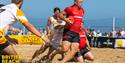Men playing rugby on the beach