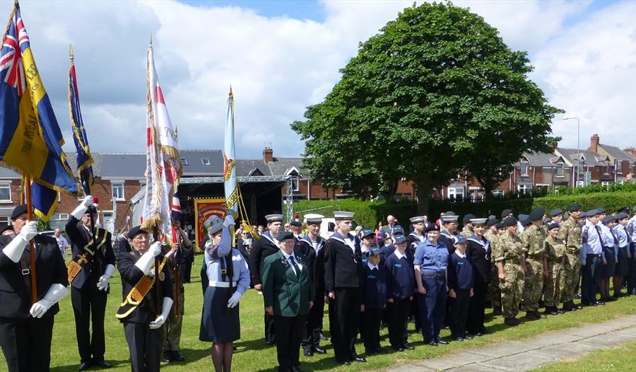 Seaham Annual Armed Forces Day. Image of members of the armed forces attending the service, lined up outside, carrying flags.