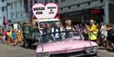 Pink cadillac leading the gay pride parade around the streets of Bournemouth on a beautiful day