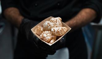 Person Holding Brown and White Pastry in a Square Box