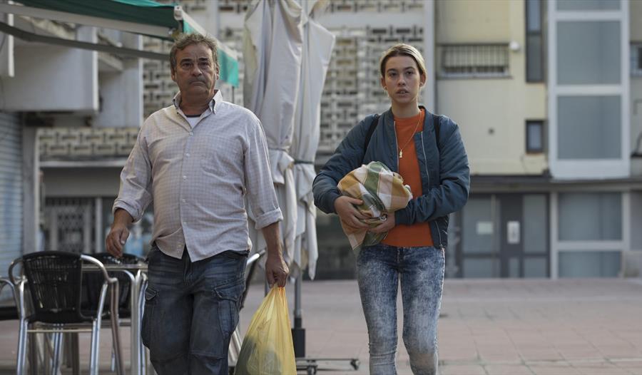 La Hija de un ladrón 2, man and woman carrying bags