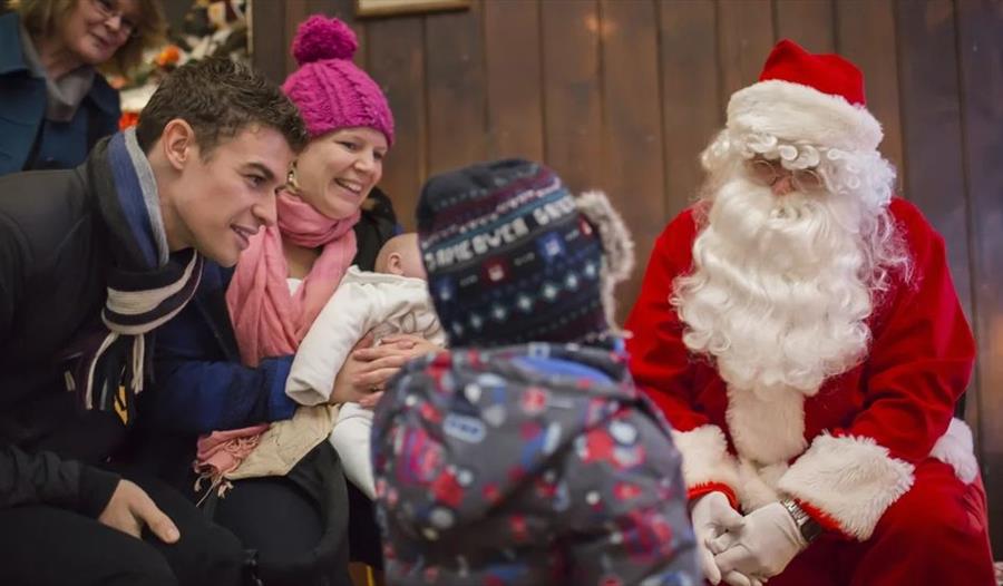 Santa meets a young family in his grotto