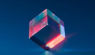 Image shows a clear glass cube with pink and blue lighting inside.