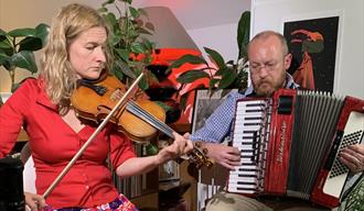 Adam Fairhall playing accordion and Olivia Moore playing violin