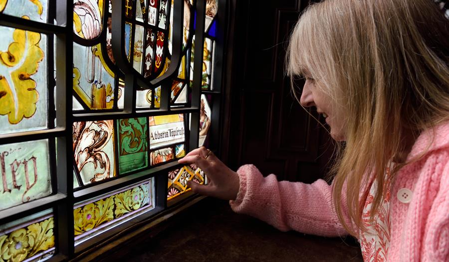 Woman looking at stained glass window
