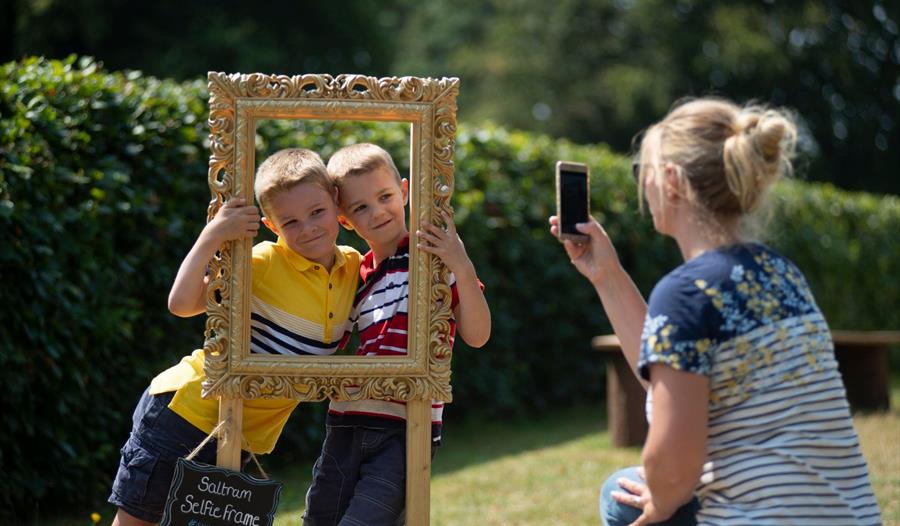Children having fun taking a selfie in a portrait frame at Saltram