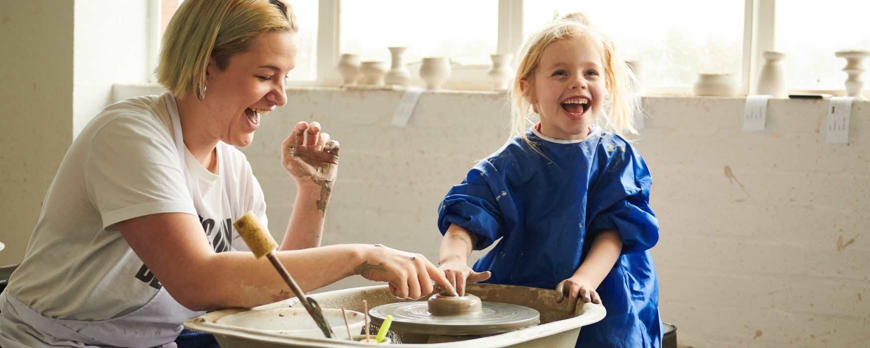Young girl laughing at throwing a pot at World of Wedgwood