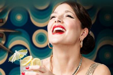 Photograph of woman laughing holding cocktail