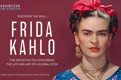 An image with a dark red background that has a woman on the right hand side of it. This woman is wearing a blue dress, gold earrings and a gold neckla