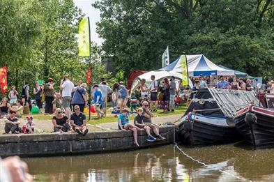 Image of people sitting on the edge of a canal.