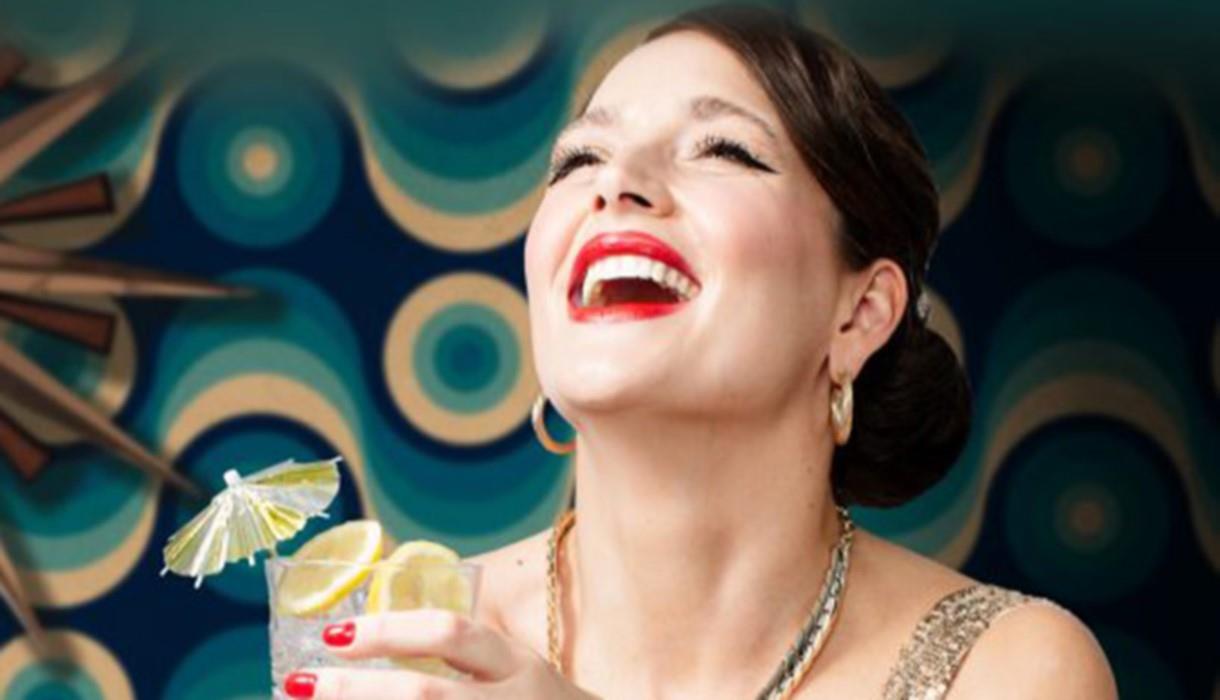 Photograph of woman laughing holding cocktail