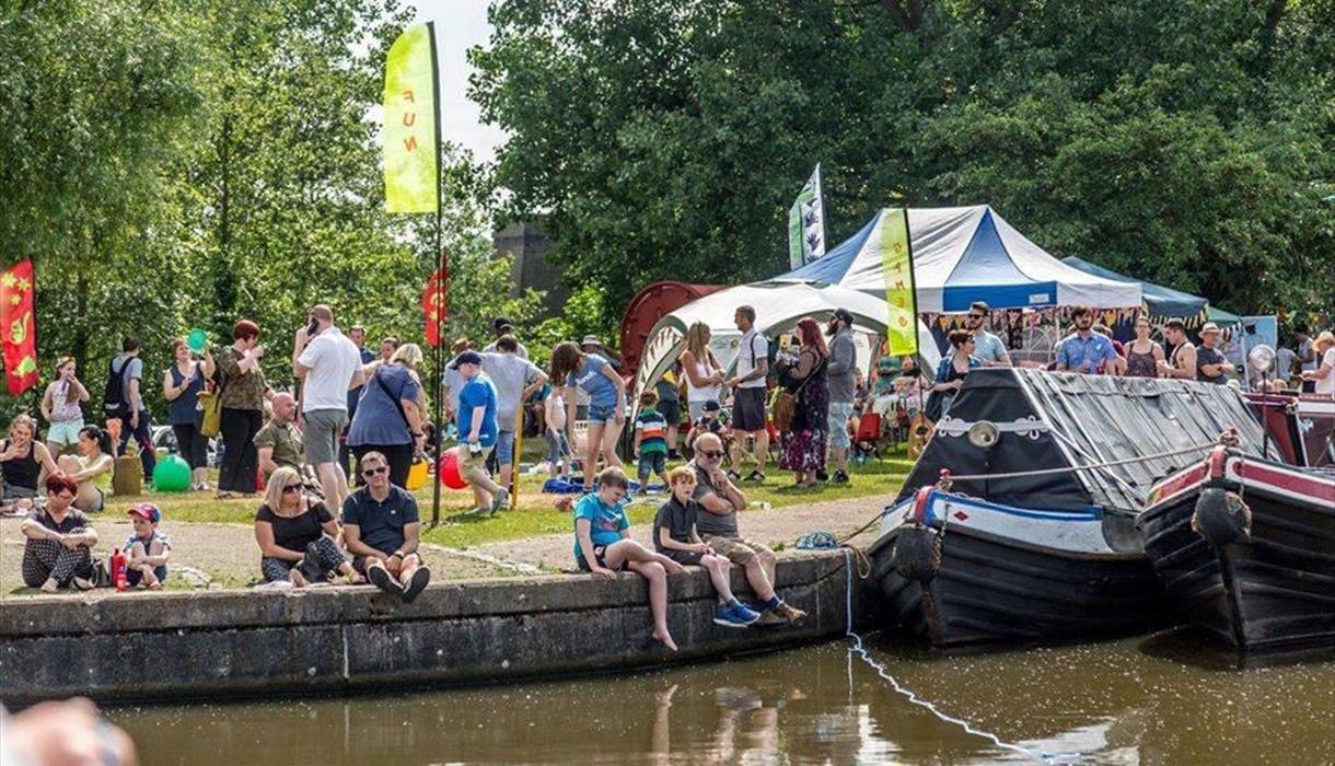 Image of people sitting on the edge of a canal.