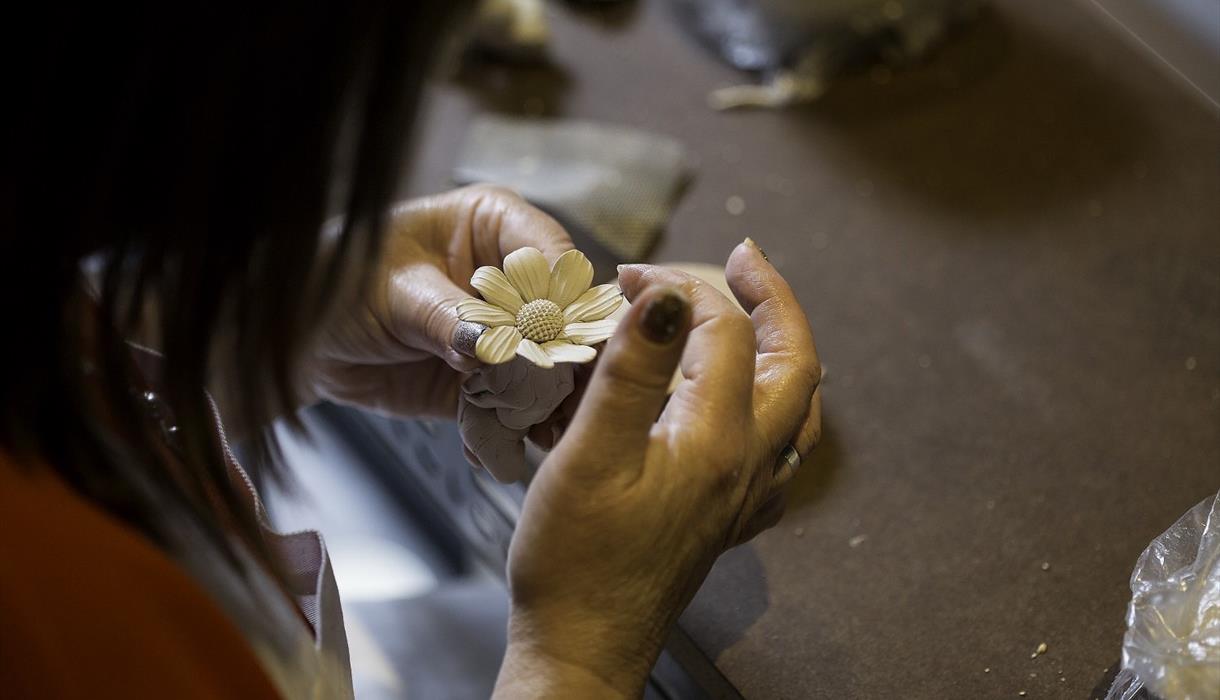 Image of a clay flower being sculpted.