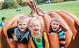 Three children hide in a giant pumpkin