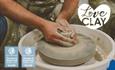Image shows a potter working at a potter's wheel, on what appears to be a vase