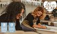 Two ladies laughing whilst throwing a pot at LoveClay Ceramics Centre