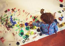 A child painting on a large piece of paper