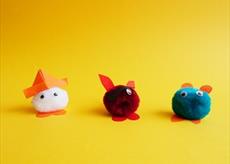 Colourful pom poms with eyes, ears and hats