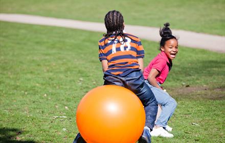 Children enjoying bouncing on space hoppers at Hatchlands Park