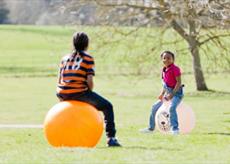 Children playing on space hoppers in the park