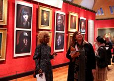 Two woman looking at the Faces of Fame exhibition at Watts Gallery