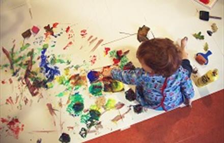A child painting on a large piece of paper